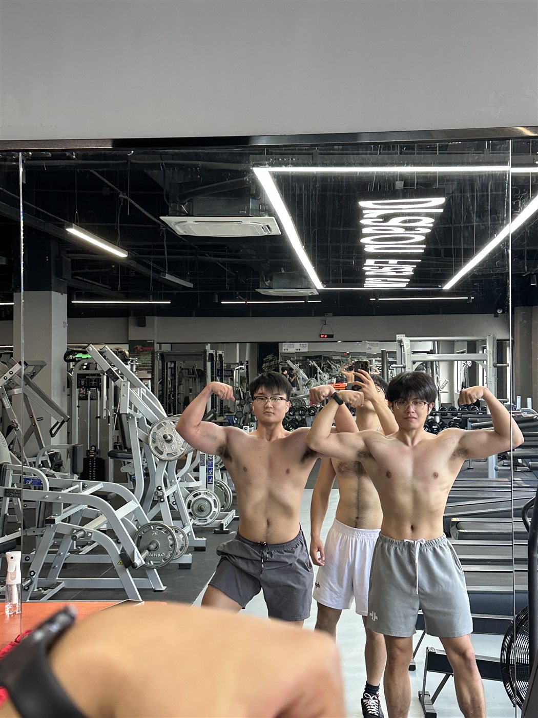 Training partners flexing in the gym mirror